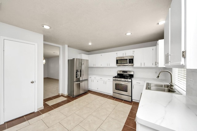 4310 Lucas Trace Ct, Houston, TX 77066 - kitchen with stainless steel appliances, a sink, white cabinets, light tile patterned floors, and backsplash