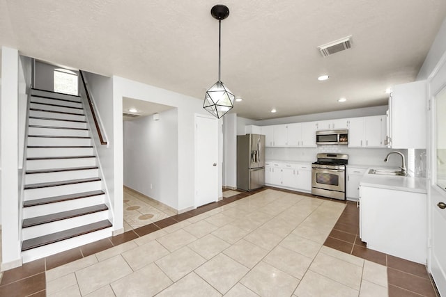 4310 Lucas Trace Ct, Houston, TX 77066 - kitchen with stainless steel appliances, a sink, light countertops, light tile patterned floors, and white cabinets