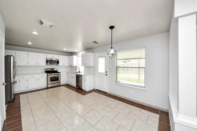 4310 Lucas Trace Ct, Houston, TX 77066 - kitchen with appliances with stainless steel finishes, a sink, light countertops, light tile patterned floors, and pendant lighting