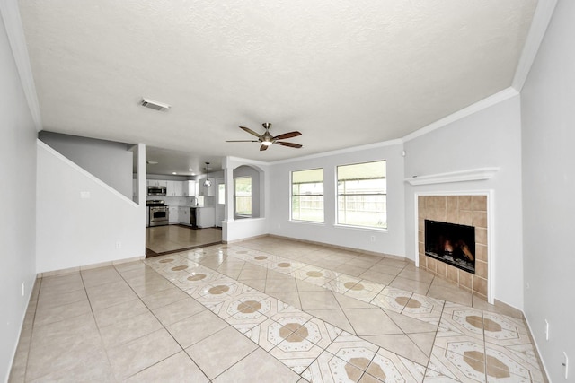 4310 Lucas Trace Ct, Houston, TX 77066 - unfurnished living room featuring crown molding, light tile patterned floors, ceiling fan, a tile fireplace, and baseboards