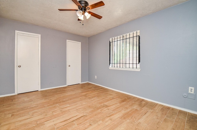 7373 Cook Rd, Houston, TX 77072 - unfurnished bedroom with light wood-style flooring, baseboards, a textured ceiling, and a ceiling fan