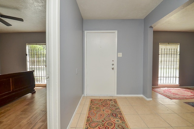 7373 Cook Rd, Houston, TX 77072 - entrance foyer with a ceiling fan, a textured ceiling, baseboards, and light tile patterned floors