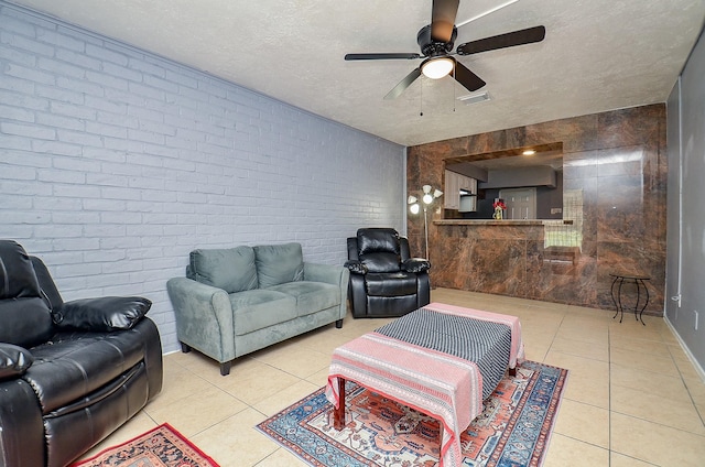 7373 Cook Rd, Houston, TX 77072 - living area featuring tile patterned floors, ceiling fan, a textured ceiling, and brick wall