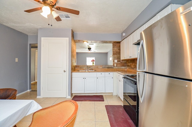 7373 Cook Rd, Houston, TX 77072 - kitchen with freestanding refrigerator, black / electric stove, a sink, ceiling fan, and white cabinets