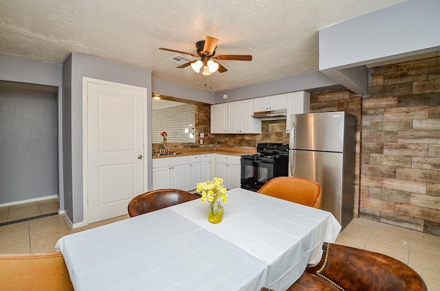 7373 Cook Rd, Houston, TX 77072 - kitchen featuring black range with electric cooktop, freestanding refrigerator, light tile patterned floors, under cabinet range hood, and a ceiling fan