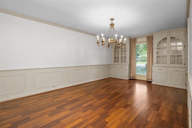 103 N Gordon Dr, Crockett, TX 75835 - unfurnished dining area with a chandelier, crown molding, dark wood finished floors, a wainscoted wall, and a decorative wall