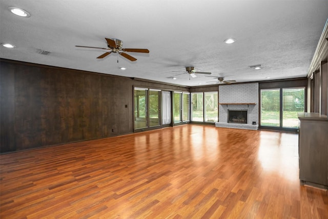 103 N Gordon Dr, Crockett, TX 75835 - unfurnished living room with ceiling fan, wood finished floors, a fireplace, a textured ceiling, and recessed lighting
