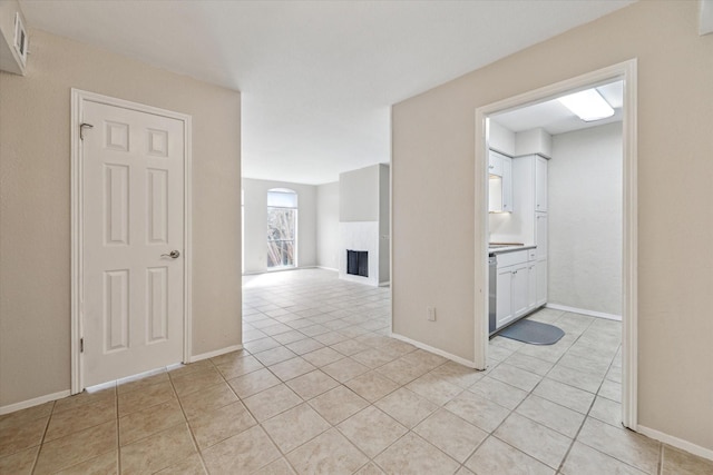 4631 Wild Indigo St Unit 575, Houston, TX 77027 - spare room featuring light tile patterned floors, a fireplace, and baseboards