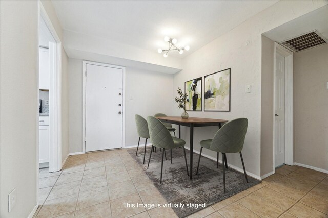 4631 Wild Indigo St Unit 575, Houston, TX 77027 - dining room featuring light tile patterned floors, baseboards, and a chandelier