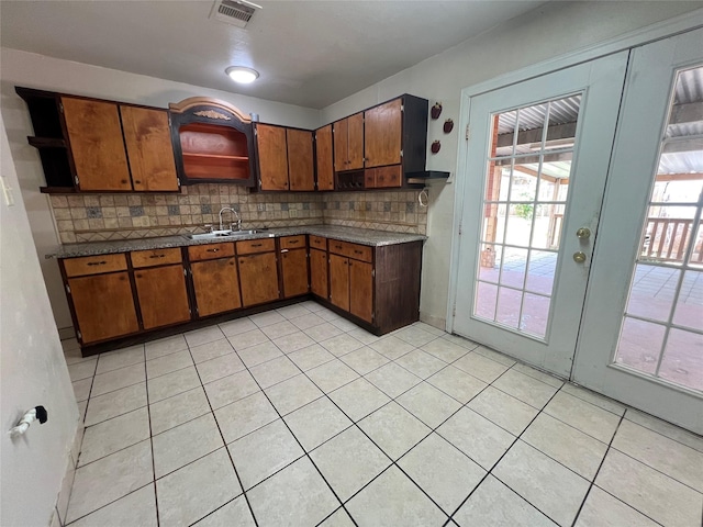 6402 Belarbor St, Houston, TX 77087 - kitchen with open shelves, brown cabinets, backsplash, a sink, and light tile patterned floors