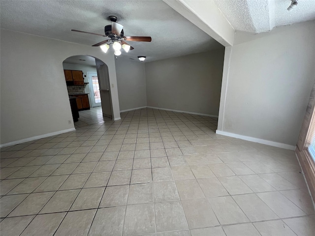 6402 Belarbor St, Houston, TX 77087 - empty room with a textured ceiling, a ceiling fan, light tile patterned floors, healthy amount of natural light, and arched walkways