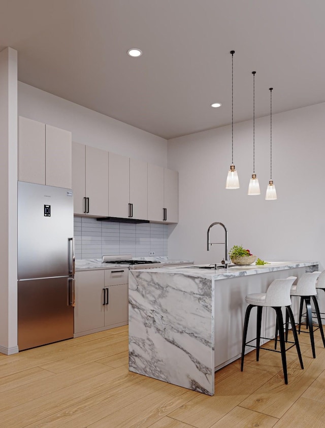4433 Phlox St, Houston, TX 77051 - kitchen featuring high end refrigerator, a kitchen bar, light wood-style floors, a sink, and recessed lighting