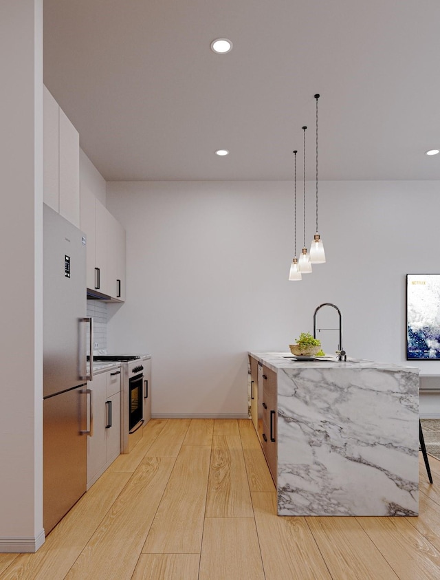 4433 Phlox St, Houston, TX 77051 - kitchen featuring freestanding refrigerator, range with gas stovetop, light wood-style flooring, white cabinets, and recessed lighting