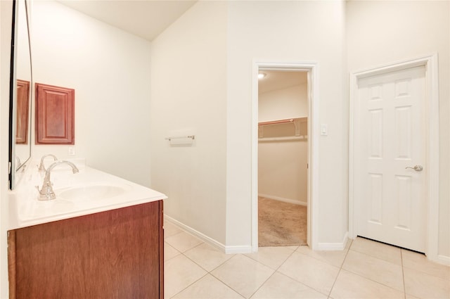 6751 Arlington Dr, Manvel, TX 77578 - bathroom featuring double vanity, tile patterned flooring, baseboards, and a walk in closet