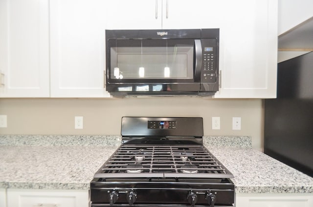 4215 Sterling St, Houston, TX 77051 - kitchen view of black appliances, white cabinets, and light stone counters