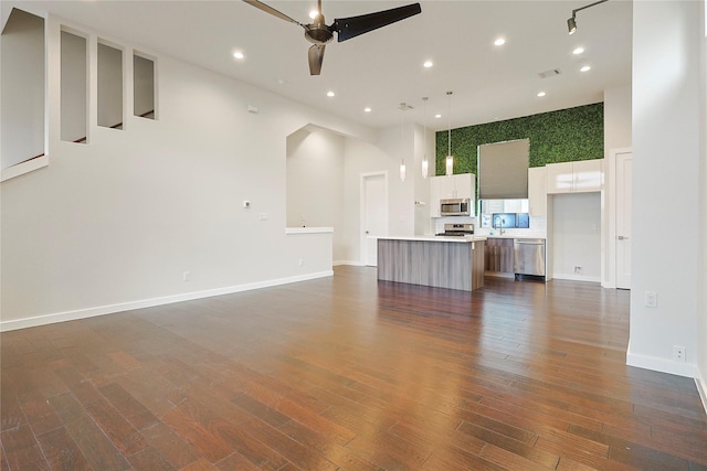 2317 Cleburne St, Houston, TX 77004 - unfurnished living room with ceiling fan, recessed lighting, a towering ceiling, dark wood-style flooring, and baseboards