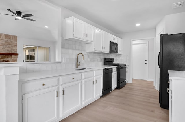 3246 Windmoor Dr, Katy, TX 77449 - kitchen featuring black appliances, a sink, white cabinetry, tasteful backsplash, and light wood finished floors