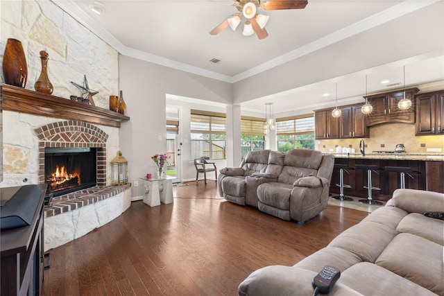 25019 Bahme Springs Ln, Porter, TX 77365 - living room featuring dark wood-style flooring, a ceiling fan, a fireplace, and ornamental molding