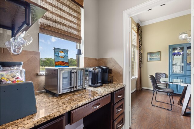 25019 Bahme Springs Ln, Porter, TX 77365 - kitchen featuring wood finished floors, crown molding, dark brown cabinetry, light stone countertops, and baseboards