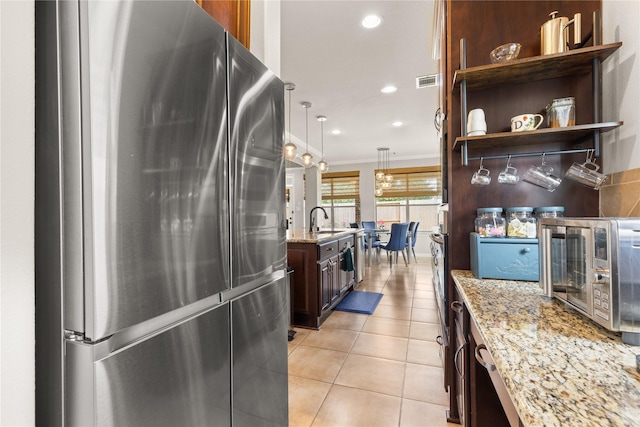 25019 Bahme Springs Ln, Porter, TX 77365 - kitchen with freestanding refrigerator, a sink, light tile patterned floors, light stone countertops, and crown molding