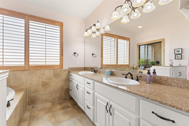 25019 Bahme Springs Ln, Porter, TX 77365 - full bath featuring double vanity, tile walls, a chandelier, a relaxing tiled tub, and a wainscoted wall