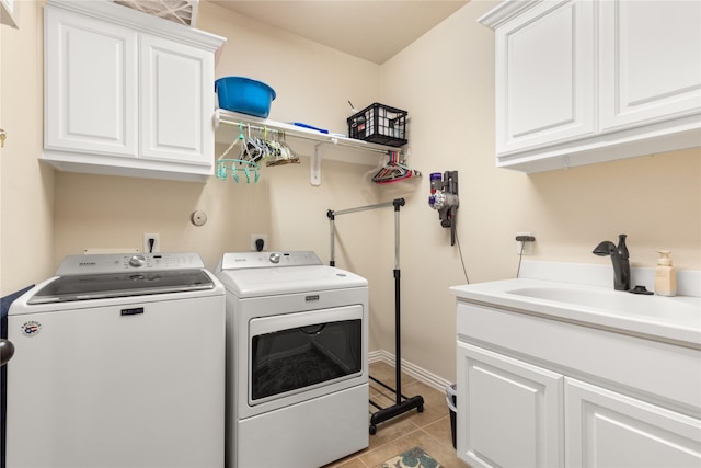 25019 Bahme Springs Ln, Porter, TX 77365 - laundry area featuring washer and dryer, cabinet space, and light tile patterned floors