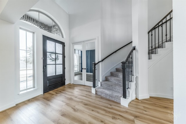 4131 Creek Shore Ln, Fulshear, TX 77441 - entrance foyer with a towering ceiling, french doors, stairs, wood finished floors, and baseboards