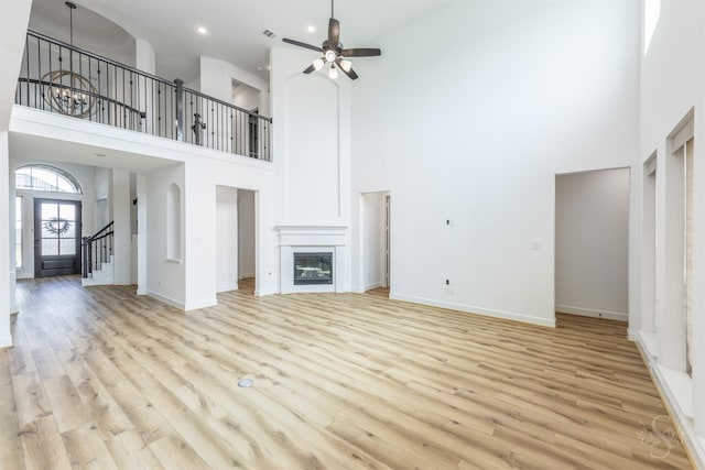 4131 Creek Shore Ln, Fulshear, TX 77441 - unfurnished living room with a towering ceiling, ceiling fan, light wood finished floors, baseboards, and recessed lighting