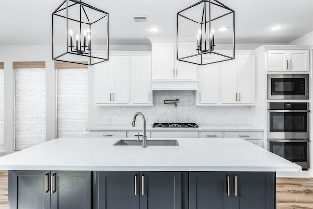 4131 Creek Shore Ln, Fulshear, TX 77441 - kitchen featuring a chandelier, stainless steel double oven, built in microwave, a sink, and light countertops