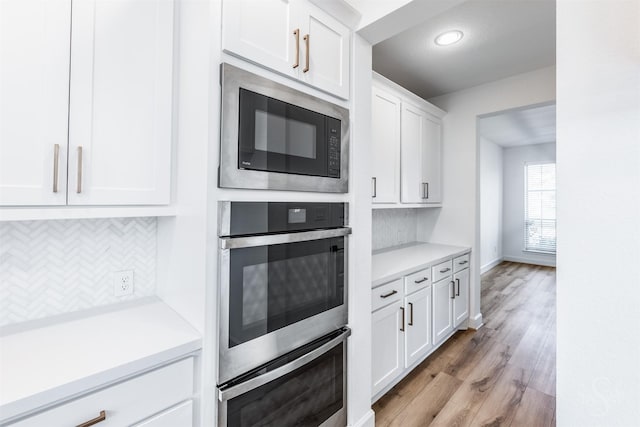 4131 Creek Shore Ln, Fulshear, TX 77441 - kitchen featuring appliances with stainless steel finishes, tasteful backsplash, light countertops, white cabinets, and recessed lighting