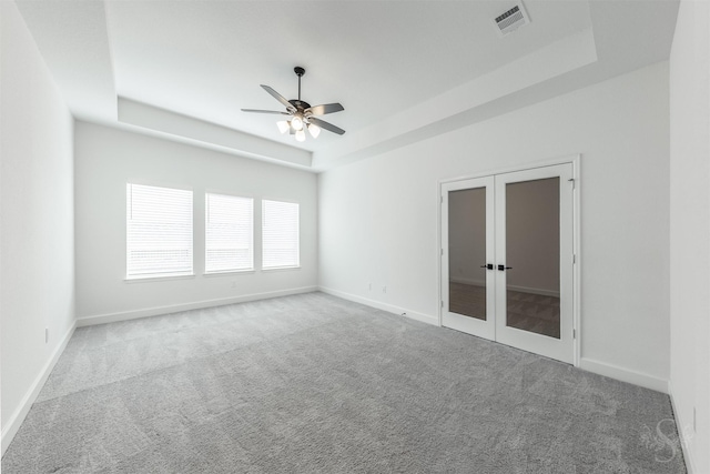 4131 Creek Shore Ln, Fulshear, TX 77441 - empty room with a raised ceiling, carpet floors, french doors, ceiling fan, and baseboards