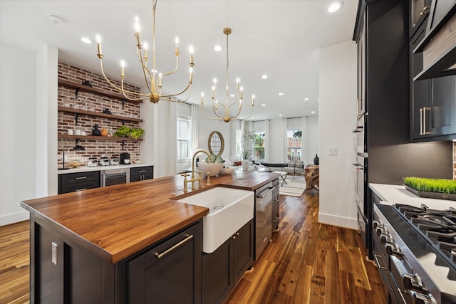 1514 31st St, Galveston, TX 77550 - kitchen with butcher block countertops, a sink, appliances with stainless steel finishes, dark wood-style flooring, and recessed lighting