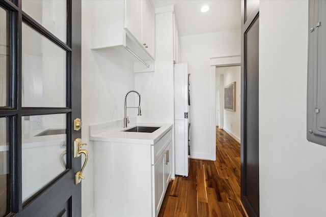 1514 31st St, Galveston, TX 77550 - laundry room featuring a sink, dark wood finished floors, stacked washer and clothes dryer, recessed lighting, and baseboards
