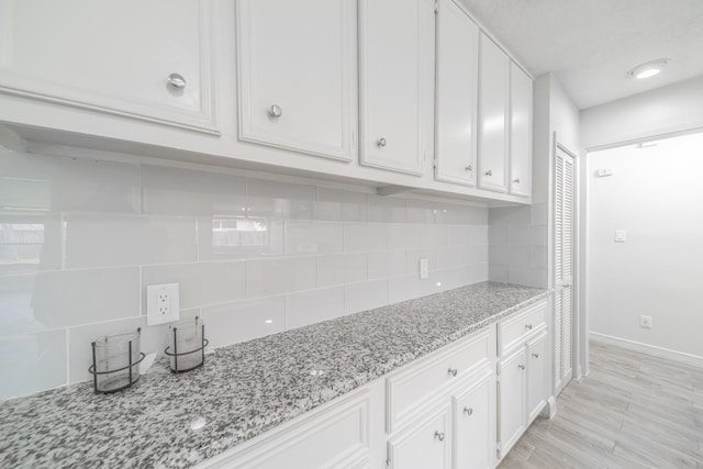 5229 W 43rd St, Houston, TX 77092 - kitchen featuring white cabinetry, backsplash, baseboards, and light stone counters