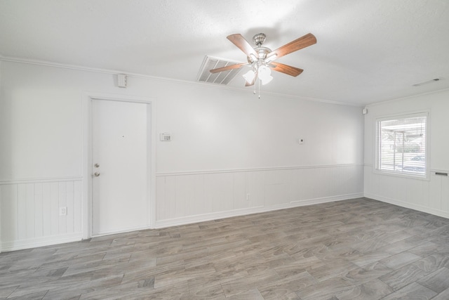 5229 W 43rd St, Houston, TX 77092 - spare room with ceiling fan, a wainscoted wall, crown molding, and light wood-type flooring