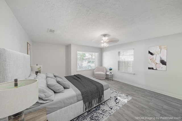 5229 W 43rd St, Houston, TX 77092 - bedroom featuring a textured ceiling, wood finished floors, baseboards, and ceiling fan