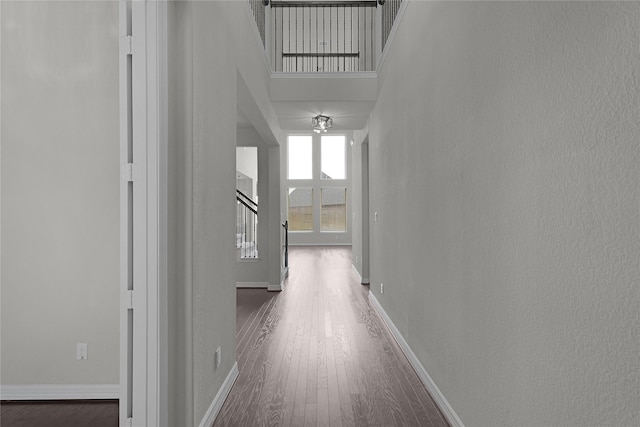 6026 Lake Bridge Ln, Manvel, TX 77578 - hallway with wood finished floors, stairs, baseboards, and a towering ceiling