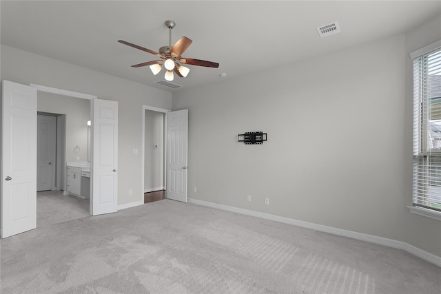 6026 Lake Bridge Ln, Manvel, TX 77578 - unfurnished bedroom with light colored carpet, baseboards, ensuite bathroom, and ceiling fan