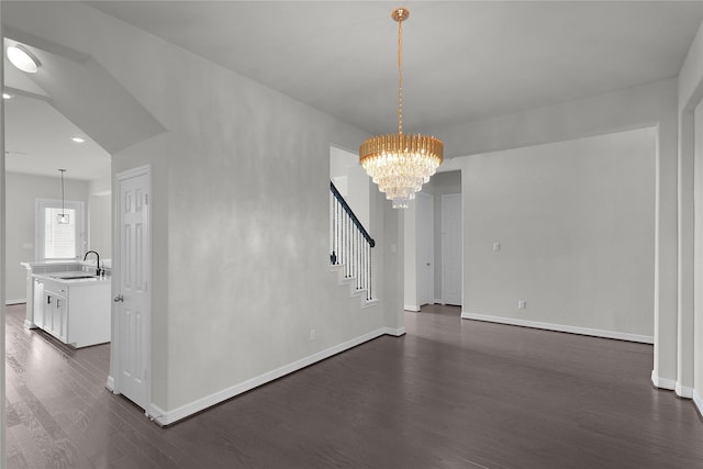 6026 Lake Bridge Ln, Manvel, TX 77578 - unfurnished dining area with a sink, a chandelier, dark wood finished floors, baseboards, and stairs