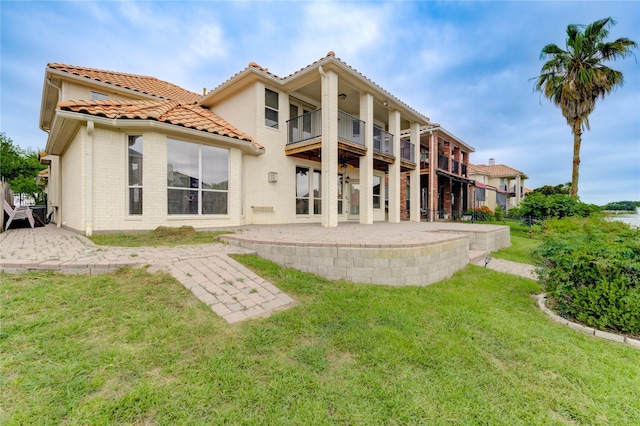 14330 Ayers Rock Rd, Sugar Land, TX 77498 - rear view of house with a balcony, a patio area, a yard, brick siding, and ceiling fan