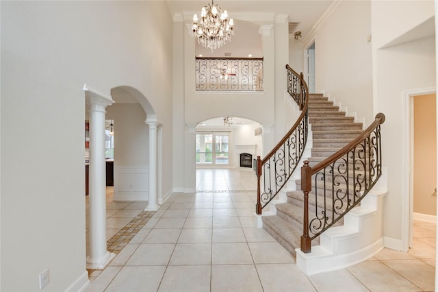 14330 Ayers Rock Rd, Sugar Land, TX 77498 - entryway featuring arched walkways, a high ceiling, tile patterned floors, a chandelier, and stairs