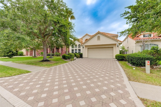 14330 Ayers Rock Rd, Sugar Land, TX 77498 - view of front of home featuring decorative driveway, an attached garage, a front lawn, a tiled roof, and stucco siding