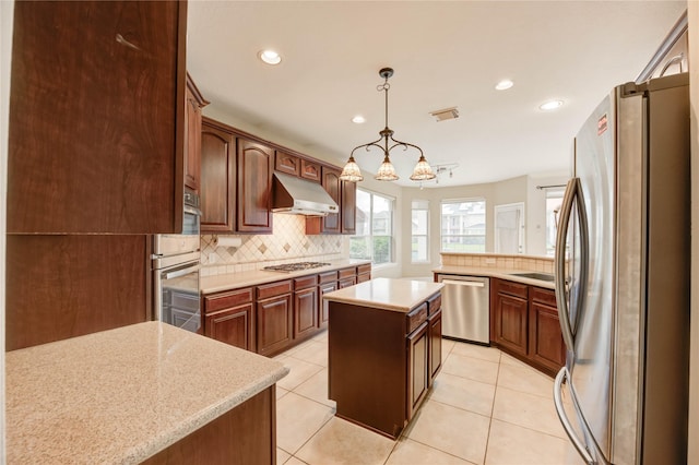 14330 Ayers Rock Rd, Sugar Land, TX 77498 - kitchen featuring stainless steel appliances, under cabinet range hood, backsplash, recessed lighting, and a center island
