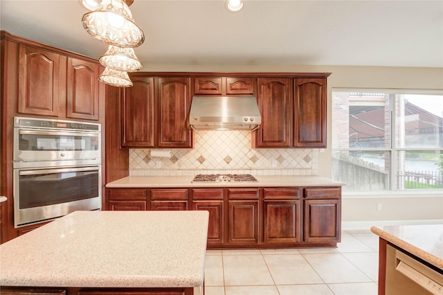 14330 Ayers Rock Rd, Sugar Land, TX 77498 - kitchen with under cabinet range hood, stainless steel appliances, plenty of natural light, and decorative backsplash