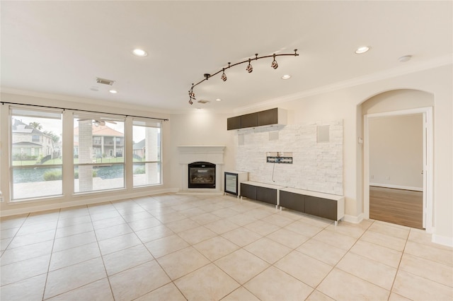 14330 Ayers Rock Rd, Sugar Land, TX 77498 - unfurnished living room featuring crown molding, light tile patterned floors, a glass covered fireplace, recessed lighting, and baseboards