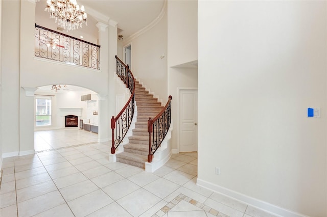14330 Ayers Rock Rd, Sugar Land, TX 77498 - entrance foyer with a fireplace, light tile patterned floors, a chandelier, a towering ceiling, and baseboards