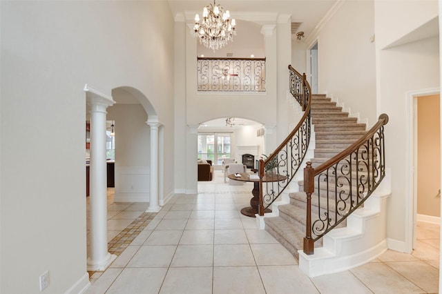 14330 Ayers Rock Rd, Sugar Land, TX 77498 - foyer entrance featuring arched walkways, tile patterned flooring, a high ceiling, stairs, and a chandelier