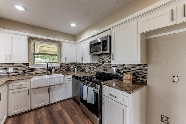 280 Crestmont St, Point Blank, TX 77364 - kitchen with stainless steel appliances, a sink, backsplash, dark wood-style flooring, and white cabinetry