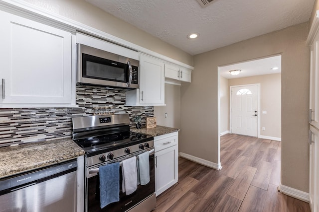280 Crestmont St, Point Blank, TX 77364 - kitchen with appliances with stainless steel finishes, white cabinets, decorative backsplash, wood finished floors, and a textured ceiling