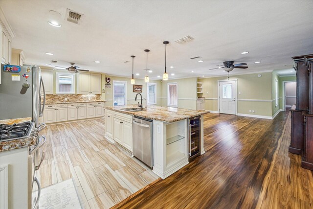 7506 Dearborn St, Houston, TX 77055 - kitchen featuring appliances with stainless steel finishes, ceiling fan, a sink, beverage cooler, and ornamental molding